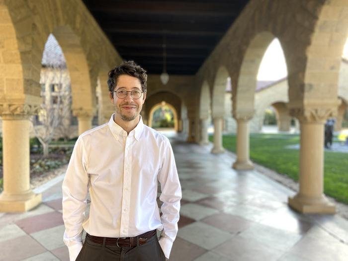 Portrait of Dr. Nicolas Garel standing under a stone arcade