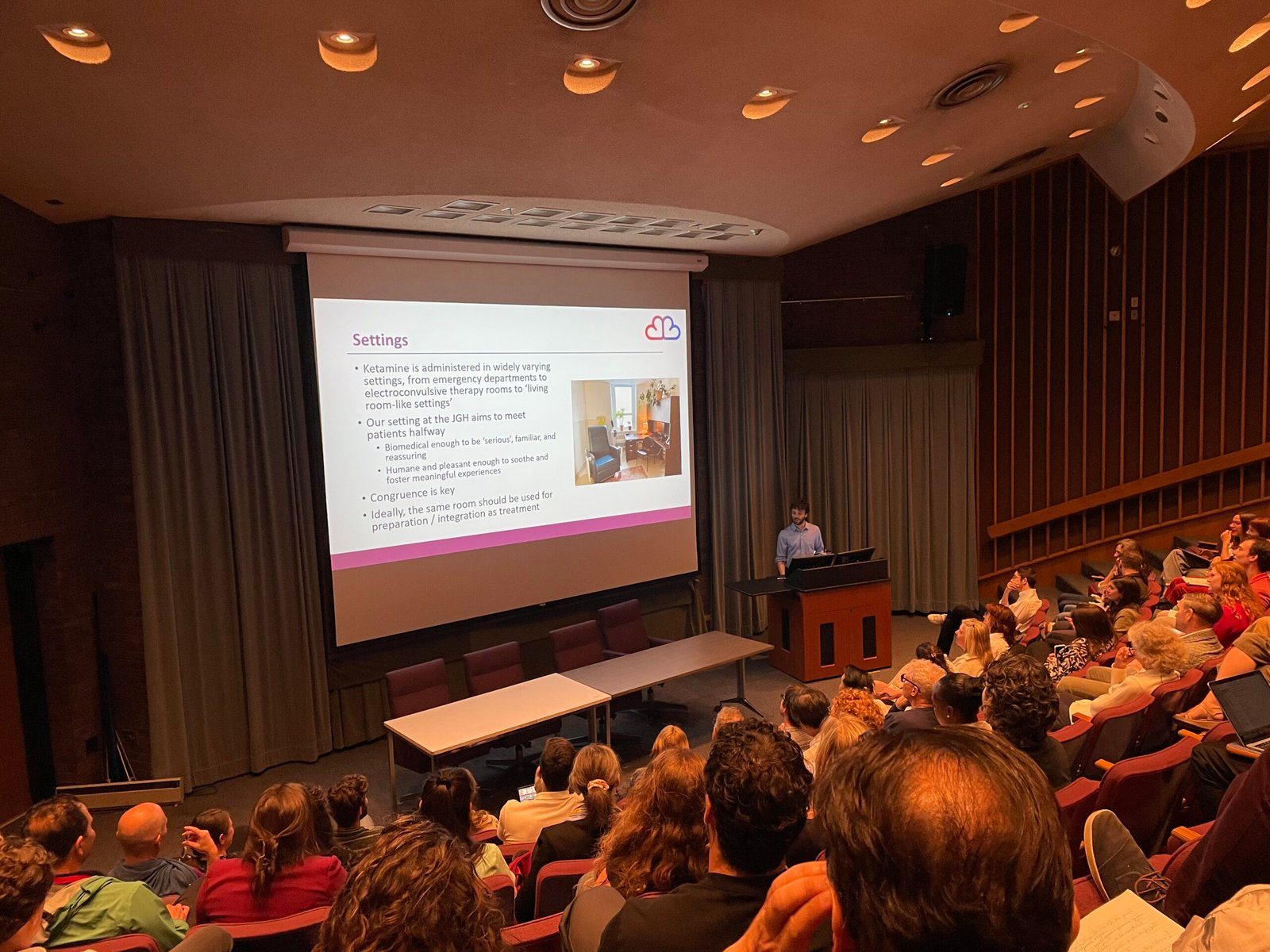 A lecture hall full of workshop participants facing a projected slide about the Montreal Model.
